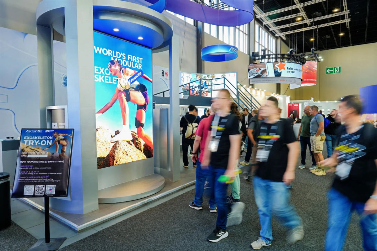 Visitors passing the Ascentiz booth and exoskeleton try-on area at IFA 2026.