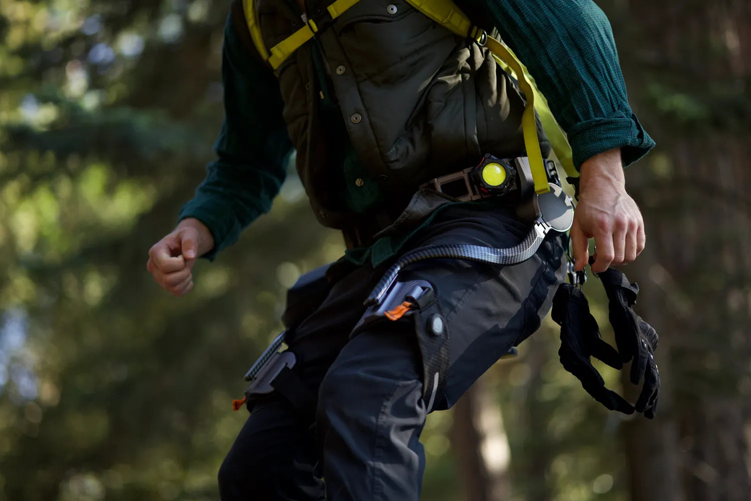 Man wearing Ascentiz H-assist exoskeleton sprinting through forest