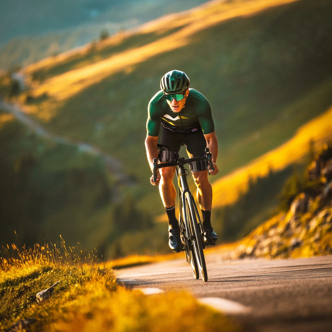 Man rides a road bike wearing the Ascentiz hip exoskeleton.