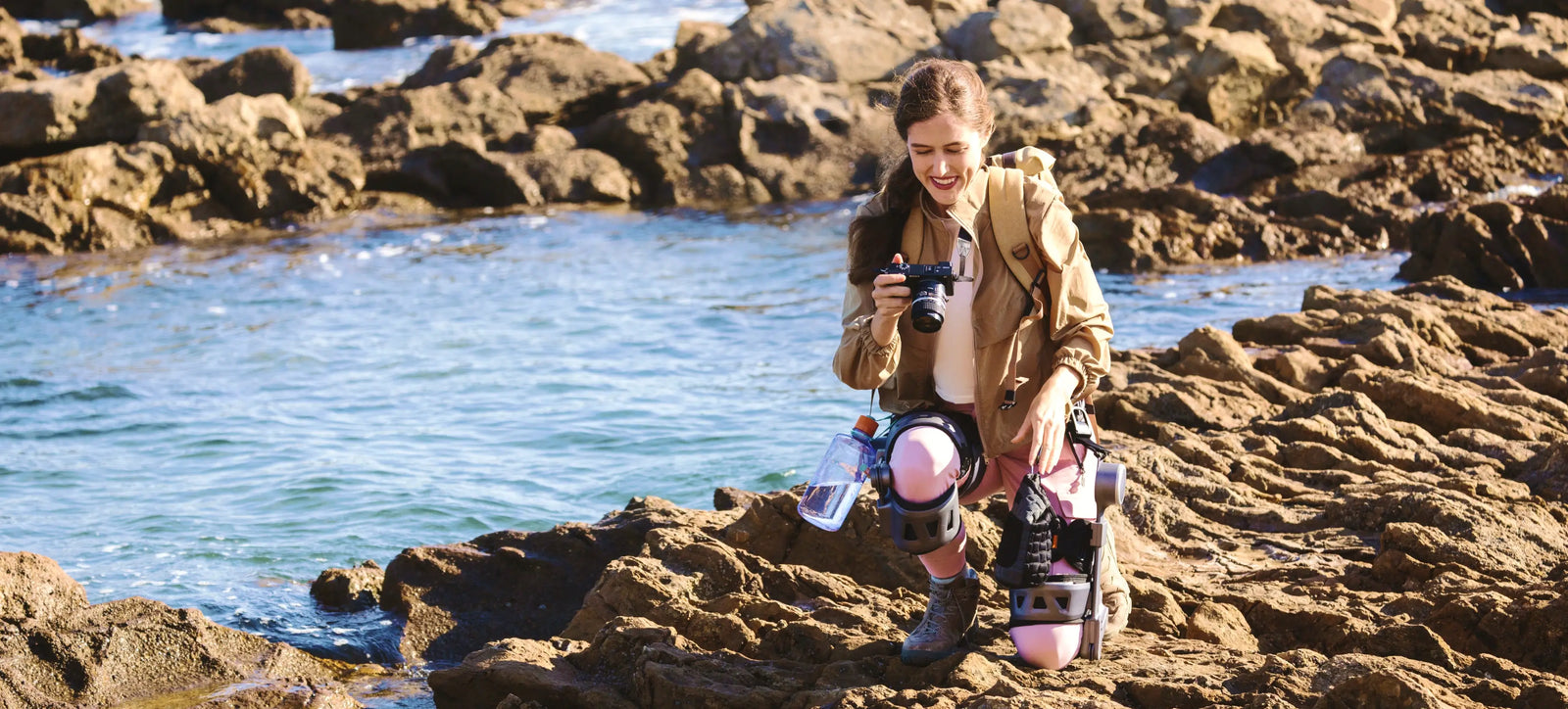 Women wearing Ascentiz exoskeleton knee kit, kneeling on the shore