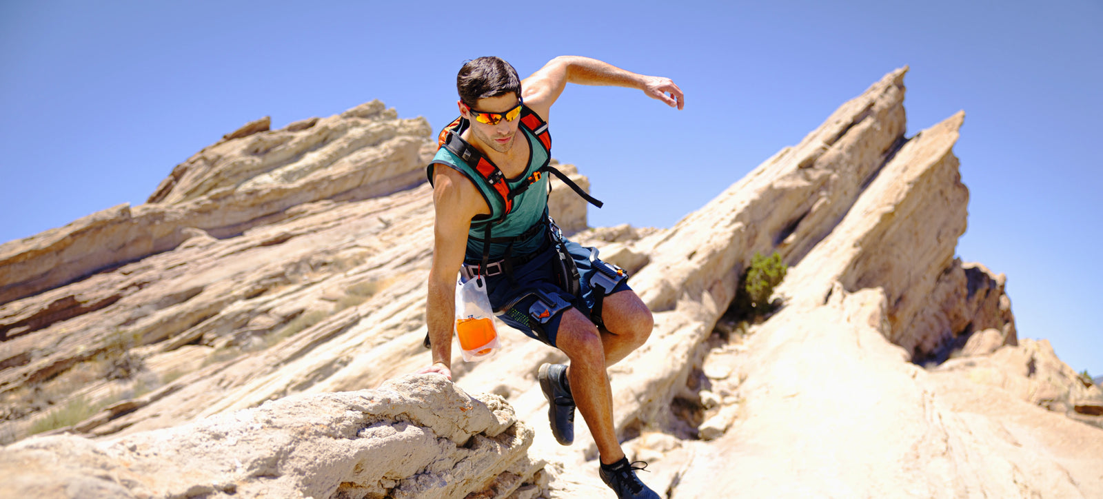 Man wearing Ascentiz hip exoskeleton jumping from a rock