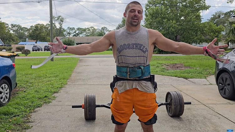 Man standing in front of a set of barbells, wearing a pair of bionic legs from Ascentiz