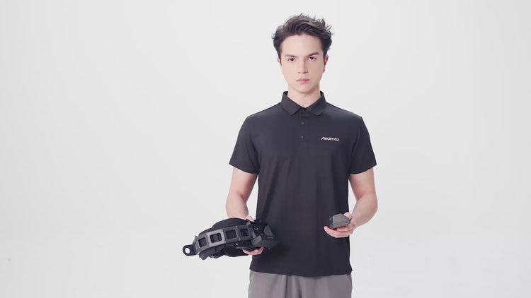 Studio shot of a model demonstrating the battery assembly process for the Ascentiz exoskeleton system, holding the chassis and battery pack module against a white background.