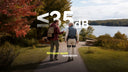 Two people walking along a park path near a lake, shown from behind. One person is wearing an Ascentiz exoskeleton that comes with whisper-quiet operation